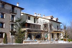 a large white building with snow on the ground at Apart-Hotel Selva Nevada in La Virgen de la Vega