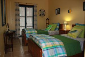 a bedroom with two beds and a window at Ti Laura Praia in Praia da Barra