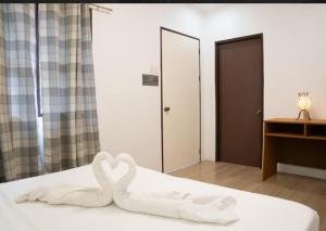 a bed with two swans made out of towels at D'Barn Hostel in Panglao Island