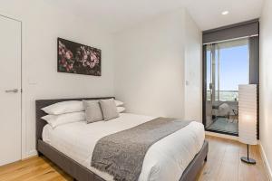 sypialnia z dużym łóżkiem i oknem w obiekcie Sunshine CBD Apt with Stunning Views plus Pool w Melbourne