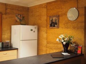 a kitchen with a refrigerator and a clock on the wall at Bundjil Studio in Healesville