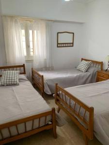 a room with three beds and a mirror at Chalet Los Primos in Miramar