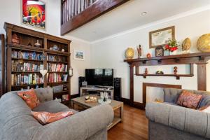 a living room with two couches and a tv at Serenity House Pemberton & Wellness Spa in Pemberton