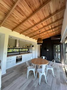 cocina con techo de madera, mesa y sillas en Casa Nera Chica, en Chapadmalal