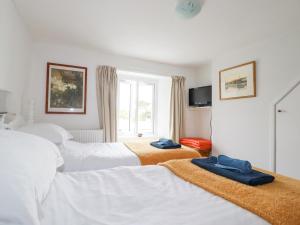 a hotel room with three beds and a window at Langurra in Newquay