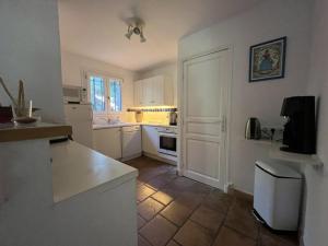 une cuisine avec des armoires blanches et un comptoir dans l'établissement Maison spacieuse avec piscine, Wi-Fi et climatisation à La Croix-Valmer - FR-1-226B-204, à La Croix-Valmer
