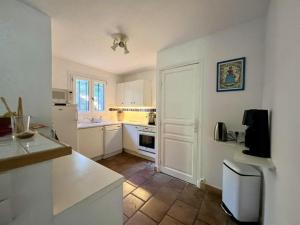 une cuisine avec des armoires blanches et un comptoir dans l'établissement Maison spacieuse avec piscine, Wi-Fi et climatisation à La Croix-Valmer - FR-1-226B-204, à La Croix-Valmer