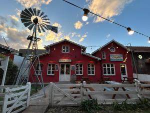 a red building with a windmill in front of it at Casa Nera Chica in Chapadmalal