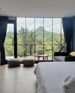 a bedroom with a bed and a large window at Playful House in Kenting