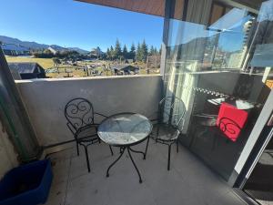 Un balcón con mesa y sillas y una vista en Apartment 01, en Hanmer Springs