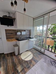 a kitchen with white cabinets and a sink and a stool at Les sablettes front de Mer Tour Fernand pouillon provence plage in La Seyne-sur-Mer +18 photos