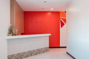 an office lobby with a red wall and a counter at Trip Inn Legazpi City near Airport in Legazpi