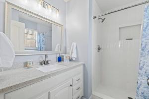 a bathroom with a sink and a mirror and a shower at Stunning Beachfront Duplex! in Saint Augustine +43 photos