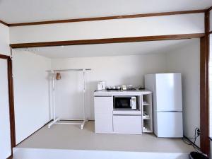 a kitchen with a refrigerator and a microwave at 飯野小屋 in Marugame