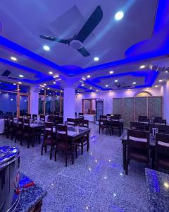 a dining room with tables and chairs and a ceiling at Hotel Lal's Inn in Kargil