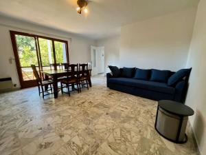 un salon avec un canapé bleu et une table dans l'établissement Maison 3 pièces avec jardin, à 2 pas du centre, 8 couchages, parking, clim et ménage inclus - FR-1-226B-208, à Cavalaire-sur-Mer