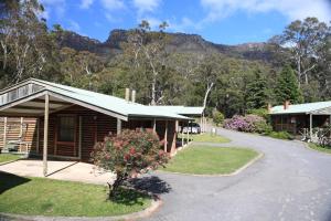 a log cabin with a mountain in the background at Halls Gap Log Cabins in Halls Gap