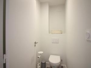 a white bathroom with a toilet in a room at Bel Apt T3 rénové avec terrasse et wifi, centre La Bourboule, proche thermes, max 5 pers - FR-1-608-270 in La Bourboule +12 photos