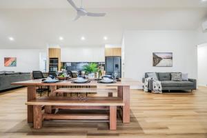 a kitchen and living room with a table and benches at Aquatic Abode in Agnes Water