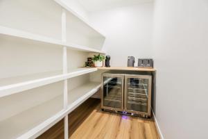 a kitchen with white walls and white shelves at Aquatic Abode in Agnes Water