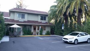 a white car parked in a parking lot in front of a house at Marin Lodge in San Rafael