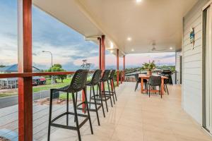 a patio with chairs and a table on a balcony at Aquatic Abode in Agnes Water