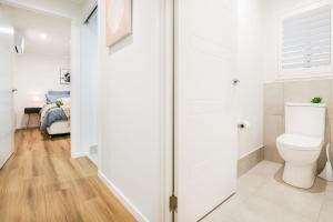 a bathroom with a toilet and a bedroom at Aquatic Abode in Agnes Water