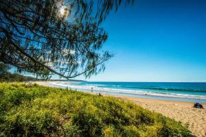 a beach with people on the sand and the ocean at Aquatic Abode in Agnes Water