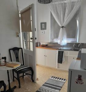 a kitchen with a table and a chair and a window at The Willery Guesthouse in Dimboola