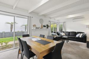 a living room with a wooden table and chairs at Mysa Anglesea Sleeps 7 WiFi SmartTV Cafes Shops in Anglesea +32 photos
