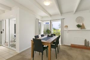 a dining room with a table and chairs at Mysa Anglesea Sleeps 7 WiFi SmartTV Cafes Shops in Anglesea