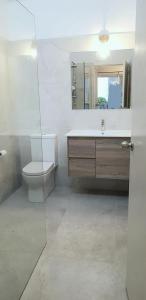 a bathroom with a toilet and a sink and a mirror at Mysa Anglesea Sleeps 7 WiFi SmartTV Cafes Shops in Anglesea