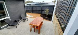 a patio with a wooden table and two chairs at Mysa Anglesea Sleeps 7 WiFi SmartTV Cafes Shops in Anglesea