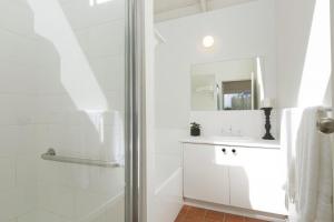 a white bathroom with a shower and a sink at Mysa Anglesea Sleeps 7 WiFi SmartTV Cafes Shops in Anglesea