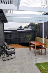 a patio with a table and a chair and a bench at Mysa Anglesea Sleeps 7 WiFi SmartTV Cafes Shops in Anglesea
