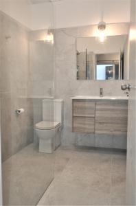 a bathroom with a toilet and a sink and a mirror at Mysa Anglesea Sleeps 7 WiFi SmartTV Cafes Shops in Anglesea