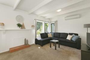 a living room with a couch and a fireplace at Mysa Anglesea Sleeps 7 WiFi SmartTV Cafes Shops in Anglesea