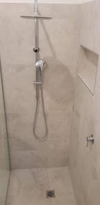 a shower with a hose in a bathroom at Mysa Anglesea Sleeps 7 WiFi SmartTV Cafes Shops in Anglesea
