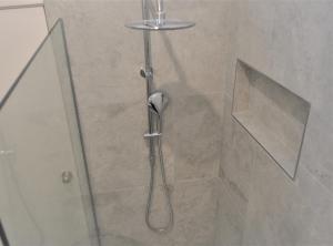 a shower with a glass door in a bathroom at Mysa Anglesea Sleeps 7 WiFi SmartTV Cafes Shops in Anglesea