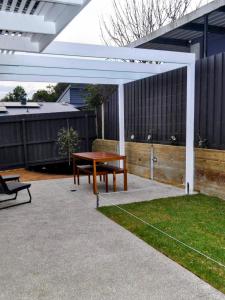 a picnic table and a bench under a pergola at Mysa Anglesea Sleeps 7 WiFi SmartTV Cafes Shops in Anglesea