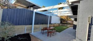 a patio with a table and a fence at Mysa Anglesea Sleeps 7 WiFi SmartTV Cafes Shops in Anglesea