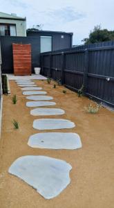 a row of white stepping stones in a yard at Mysa Anglesea Sleeps 7 WiFi SmartTV Cafes Shops in Anglesea