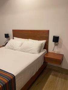 sypialnia z łóżkiem z drewnianym zagłówkiem i 2 lampami w obiekcie Ribera del Rio Club Resort w mieście Cieneguilla