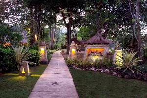 a walkway in a park at night at Pool Villa Merumatta Senggigi in Senggigi