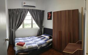 a small bedroom with a bed and a window at Seruni Apartment - 3 Bedrooms in Serendah