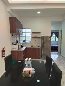 a kitchen with a table with two water bottles on it at Seruni Apartment - 3 Bedrooms in Serendah