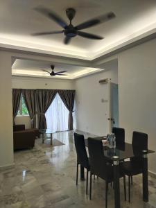 a dining room with a ceiling fan and a table and chairs at Seruni Apartment - 3 Bedrooms in Serendah