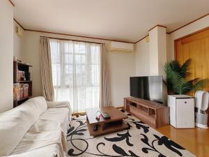 ein Wohnzimmer mit Couch und Flachbildfernseher in der Unterkunft 大阪民泊ー和の家 in Osaka