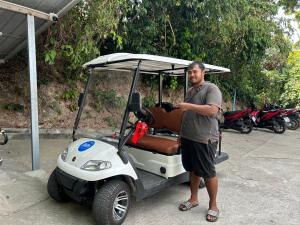 a man standing next to a golf cart at Cookies Salad Resort in Salad Beach