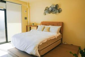 a bedroom with a bed with white sheets and pillows at Lina Suites Deluxe Room in Malaybalay